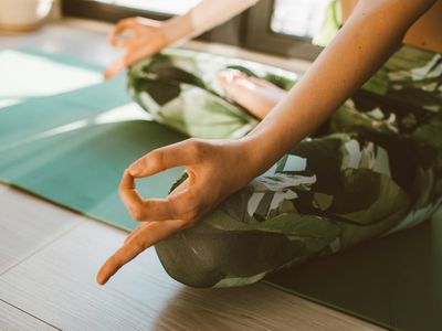 Person hands balancing on a yoga mat during practice.